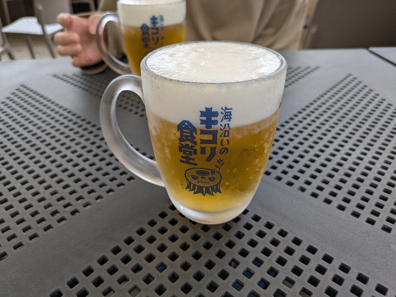 海沿いの キコリ食堂のロゴが入ったグラスに注がれたビール