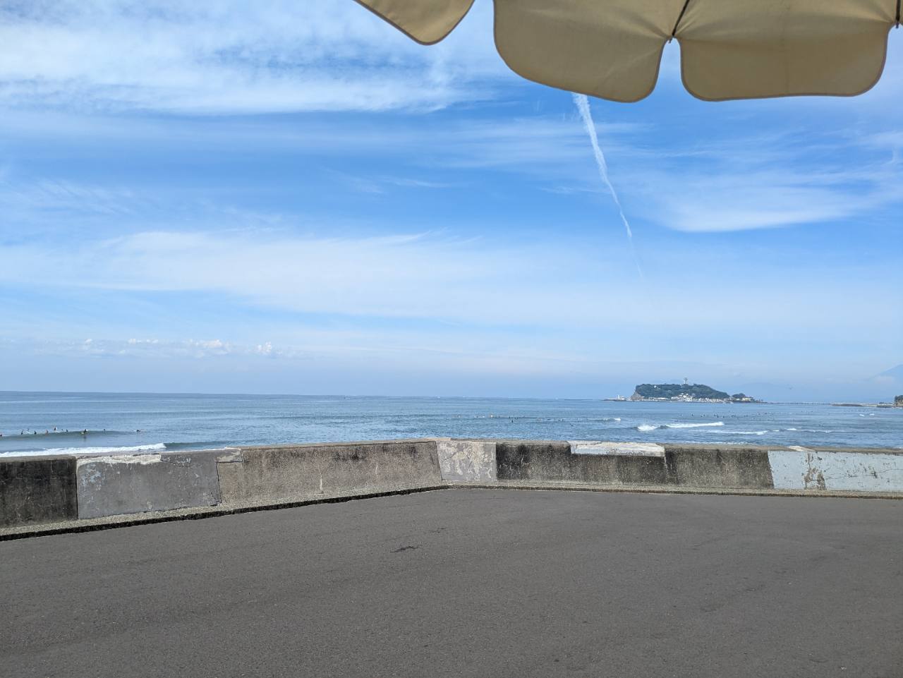 Pacific DRIVE-INのパラソル越しに広がる七里ヶ浜の海と青空