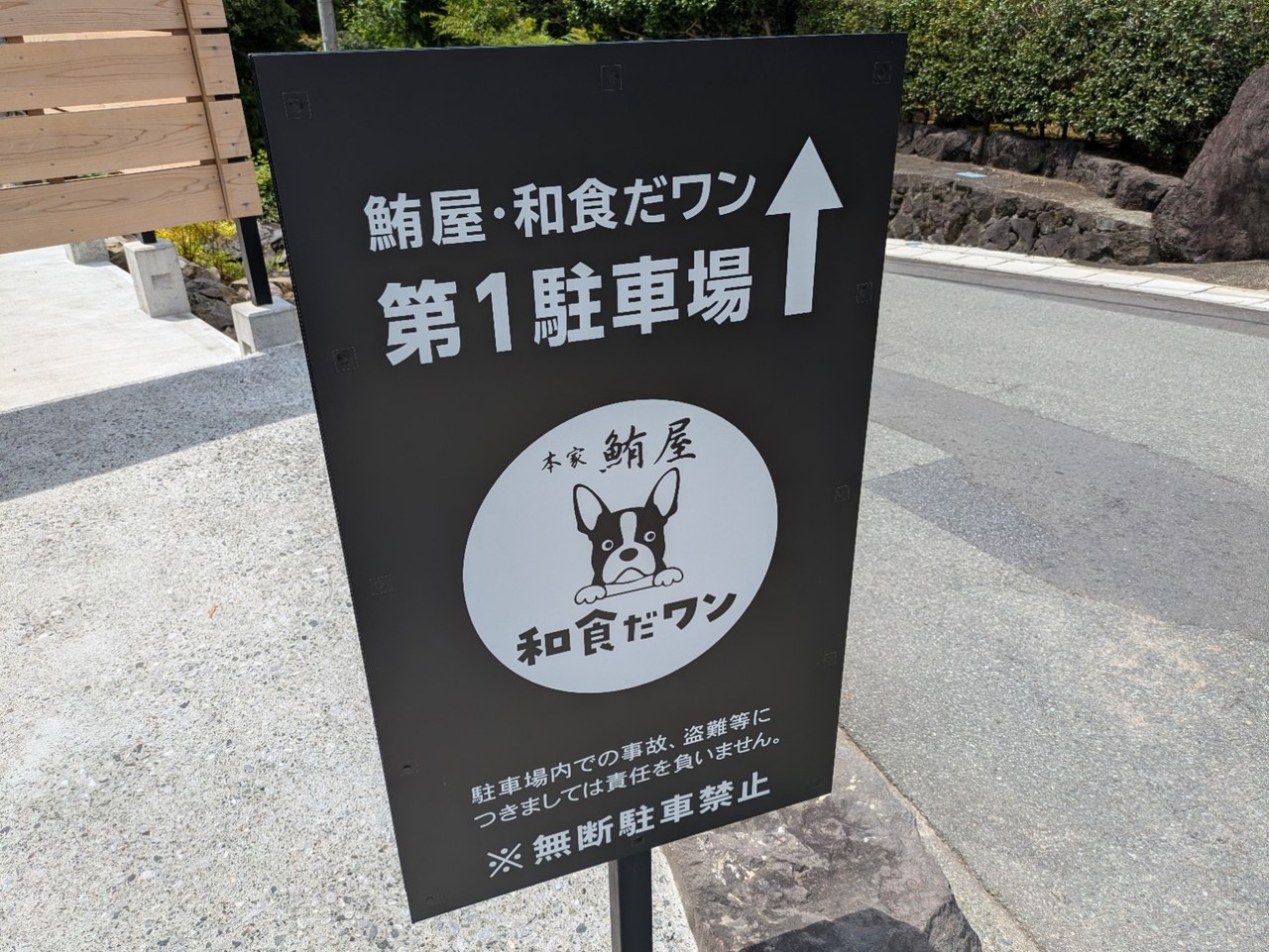 鮪屋・和食だワンの第1駐車場を矢印で案内する黒い看板